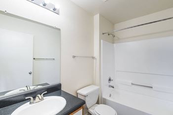 A white bathroom with a sink, toilet, and bathtub.
